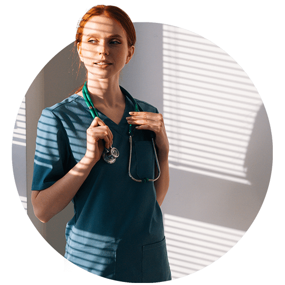 Nurse in teal scrubs staring to the right toward a patient with stethoscope